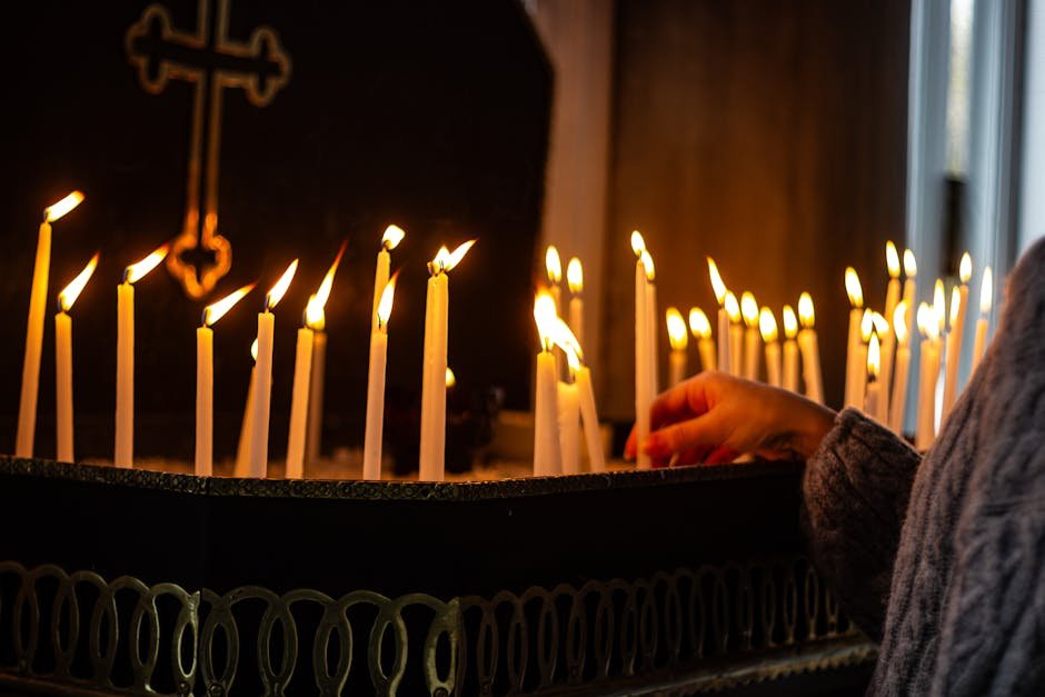 person putting candle in church