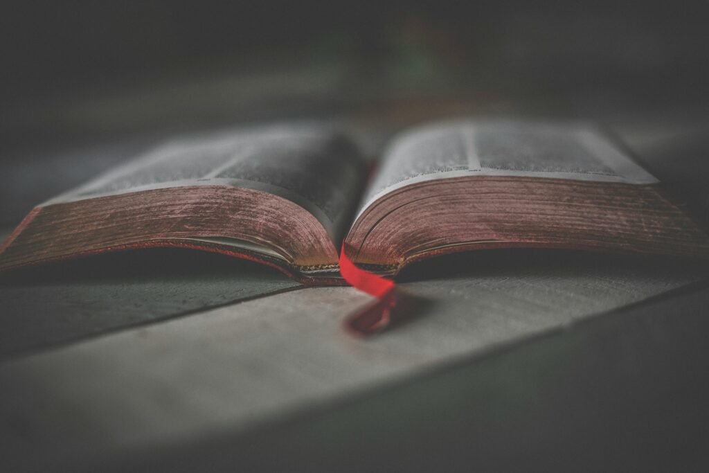 Close-up of an open religious book with a red ribbon, offering a soft, contemplative atmosphere.