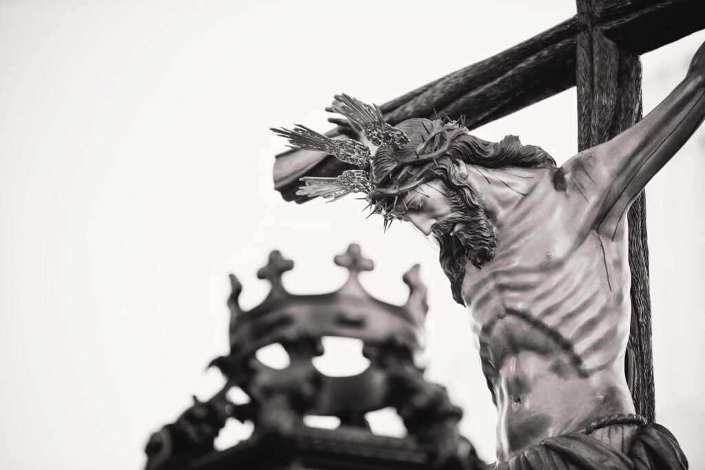 A dramatic close-up of a crucifix statue outdoors in Carmona, Spain, highlighting religious symbolism.