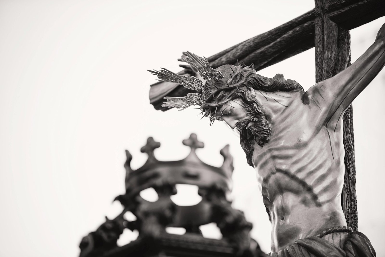 A dramatic close-up of a crucifix statue outdoors in Carmona, Spain, highlighting religious symbolism.