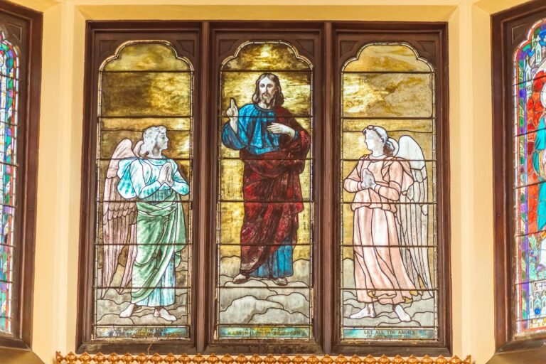 Beautiful stained glass portraying religious figures in a Catholic church setting.