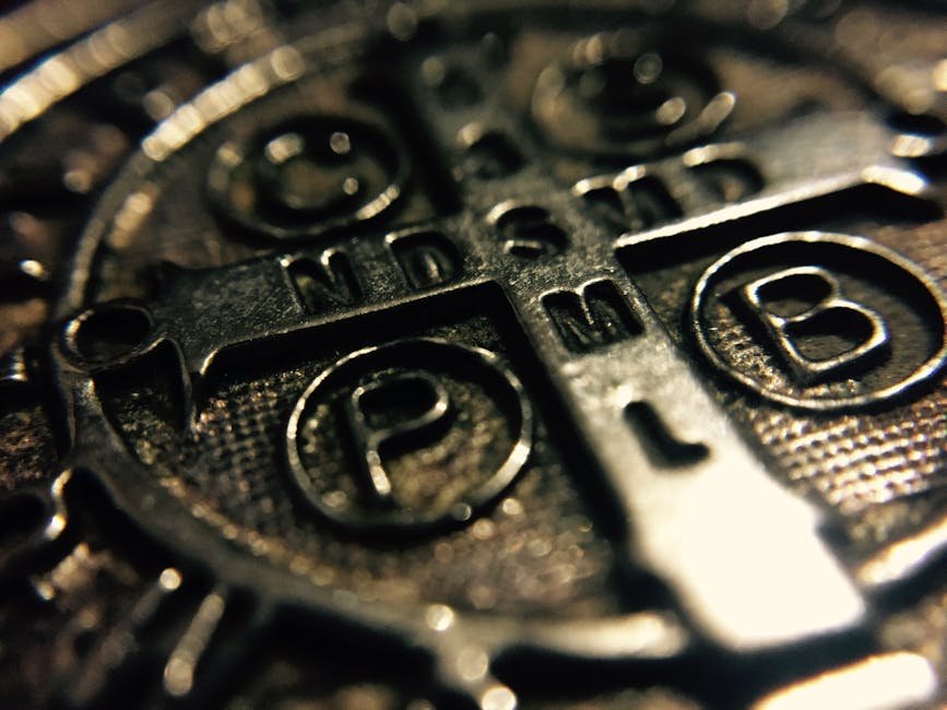 Macro shot of a metallic Saint Benedict medal with intricate religious inscriptions.